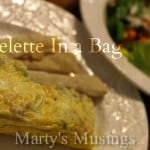 Omelette on white serving plate with bread sticks and salad