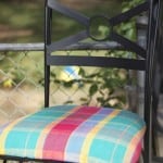 Black wrought iron chair with plaid green yellow and pink fabric
