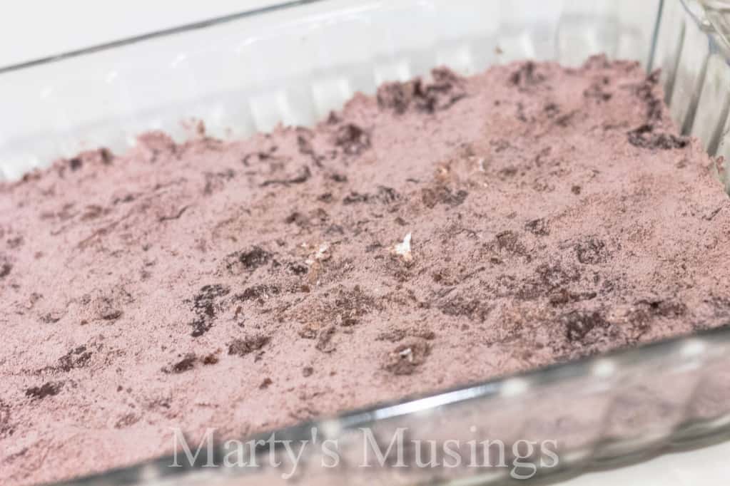 Almost Like Candy Bars chocolate brownie mixture topped with whipped topping on a white plate