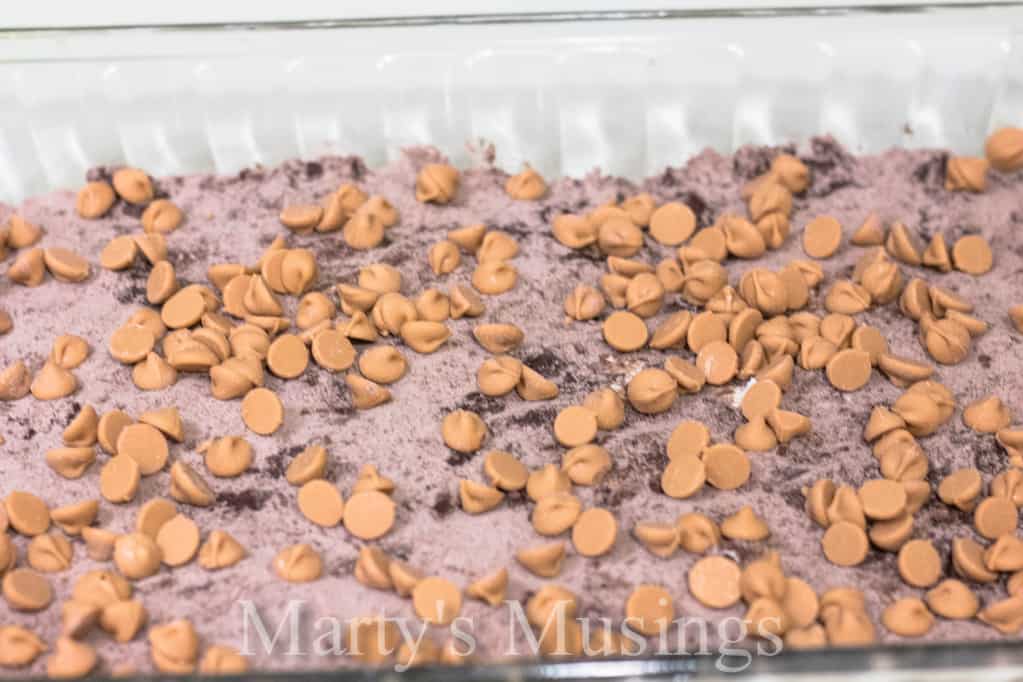Almost Like Candy Bars chocolate brownie mixture topped with whipped topping on a white plate
