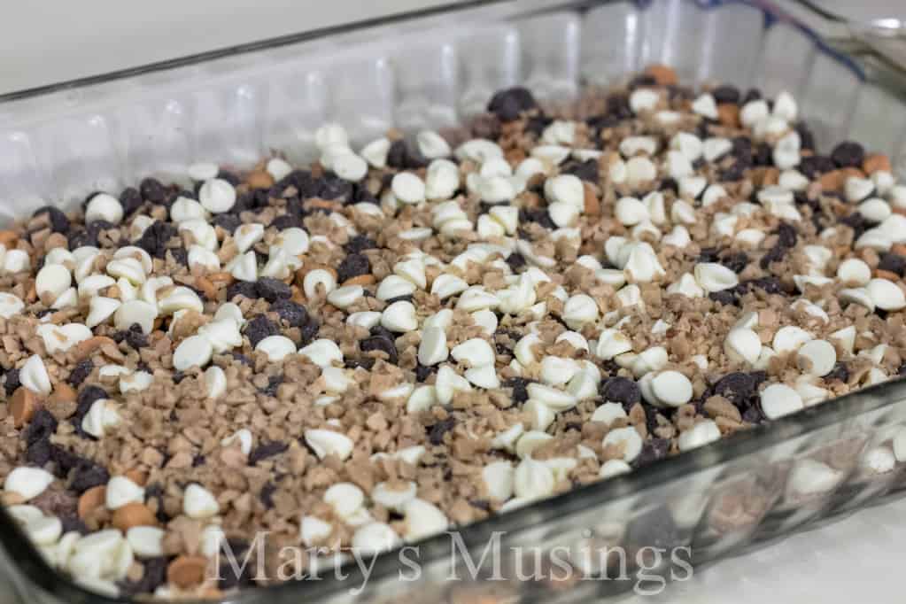 Almost Like Candy Bars chocolate brownie mixture topped with whipped topping on a white plate