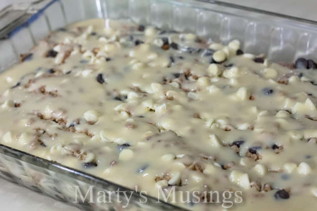 Almost Like Candy Bars chocolate brownie mixture topped with whipped topping on a white plate