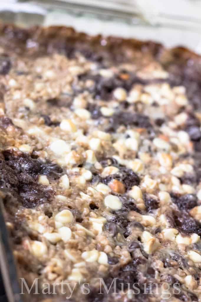 Almost Like Candy Bars chocolate brownie mixture topped with whipped topping on a white plate