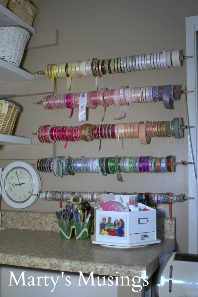 dowel rods with ribbons stored on craft room wall