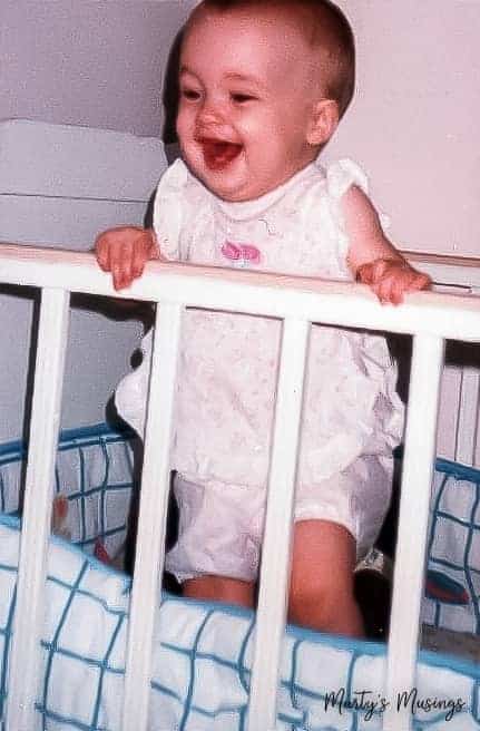 Baby standing in crib and laughing