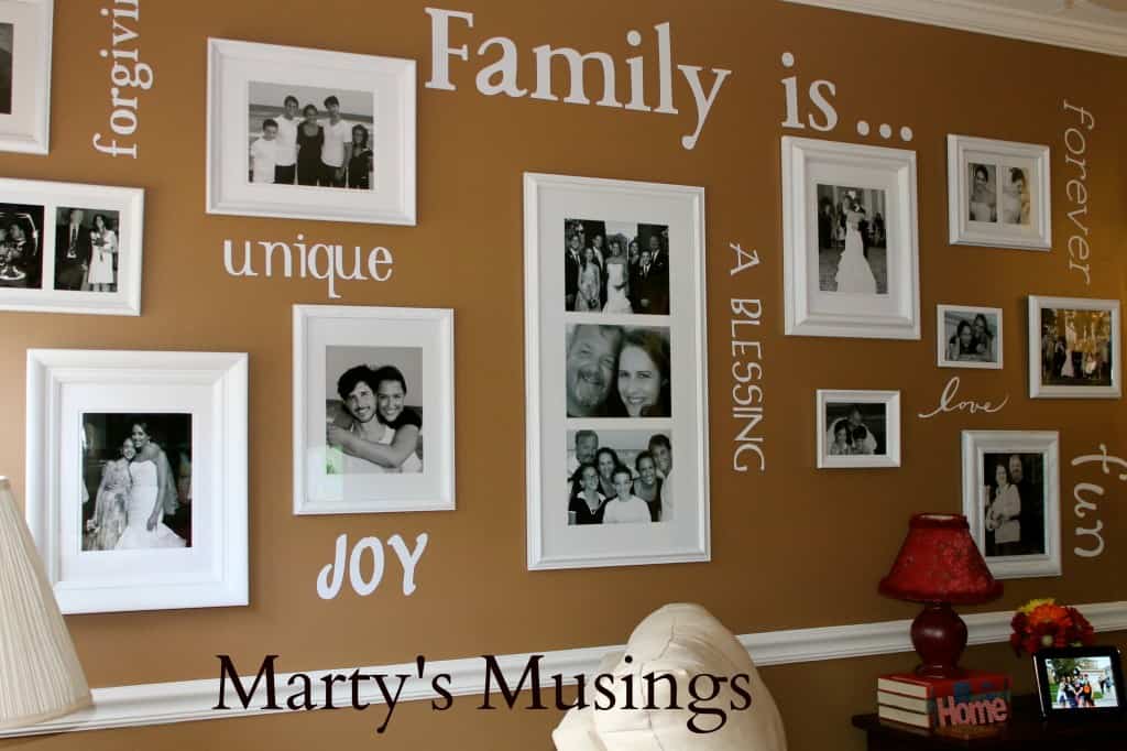 Chocolate brown wall filled with the words Family Is……unique, joy, chosen, a blessing, forever, love, fun, forgiven, cut from white vinyl with Cricut die cut machine, with black and white pictures in white frames