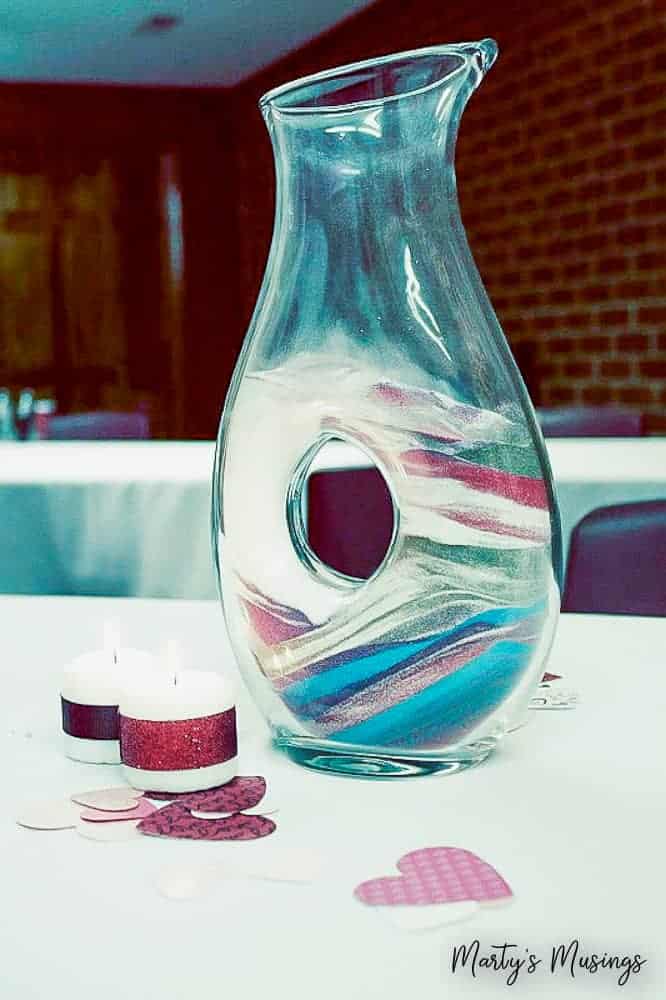 Layers of sand in specialty glass jar representing family on 25th wedding anniversary