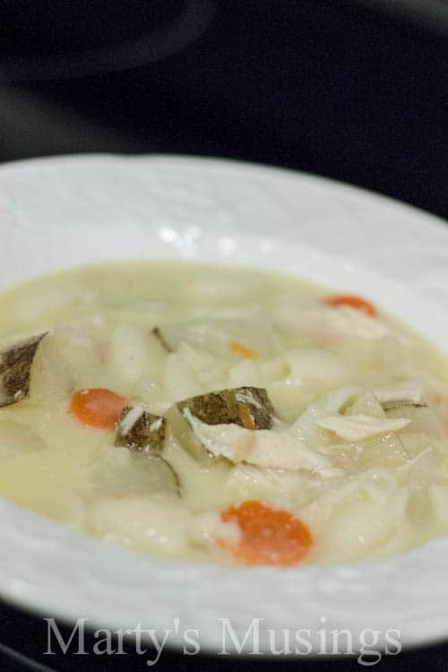 A bowl of food on a plate, with Soup