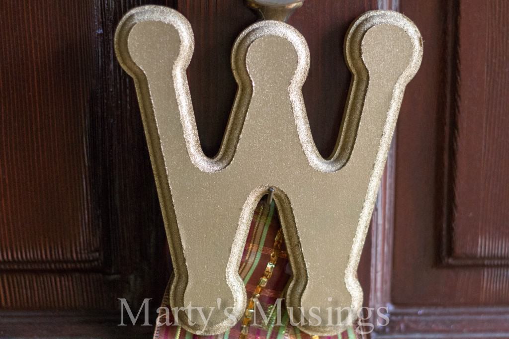 Large wooden monogram W spray painted gold and hung on wood front door