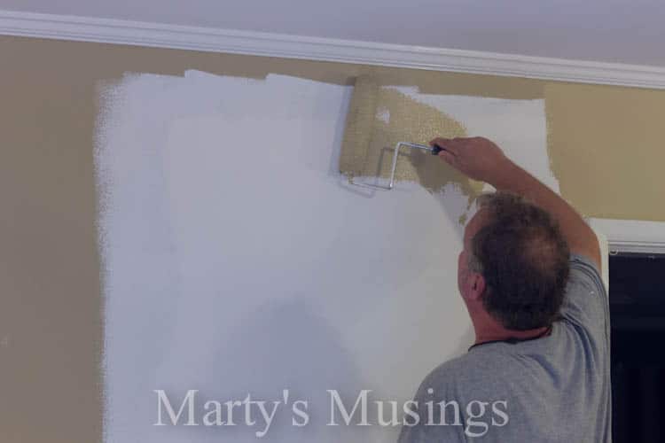 Man painting wall with neutral color