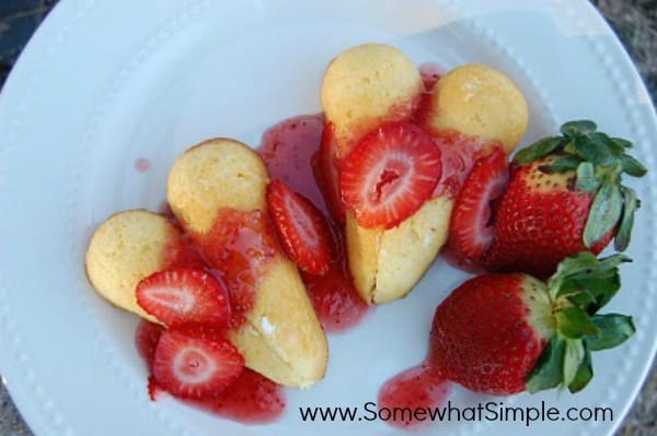 A bowl of fruit on a plate, with Strawberry and Twinkie