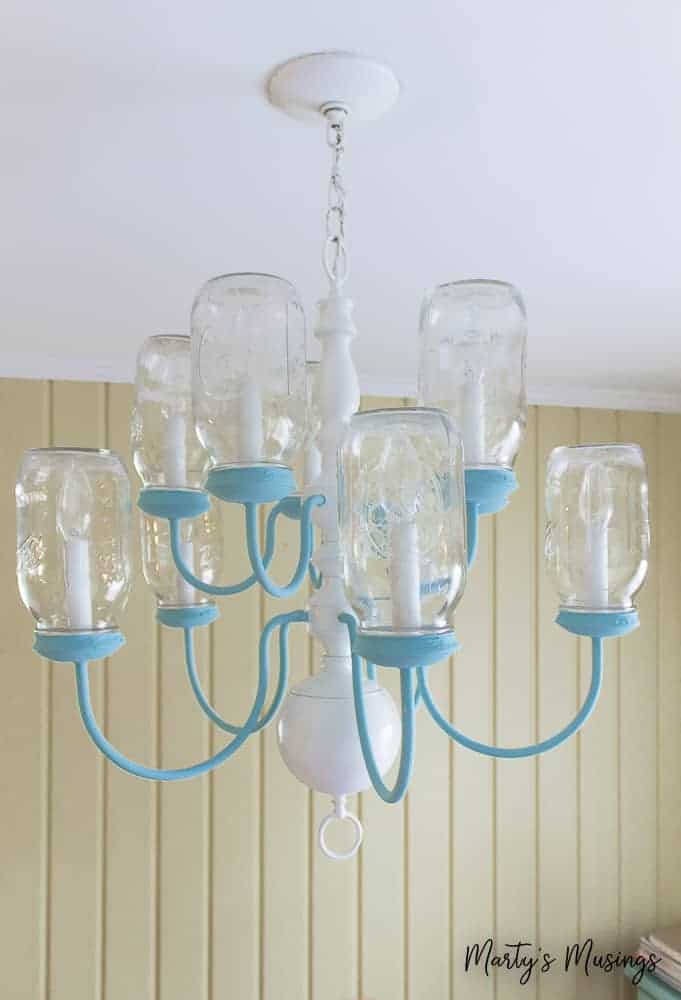 Chandelier painted with blue chalk paint hanging in kitchen