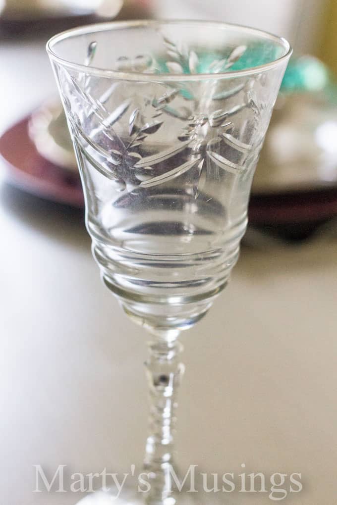 A glass cup on a table, with Jar