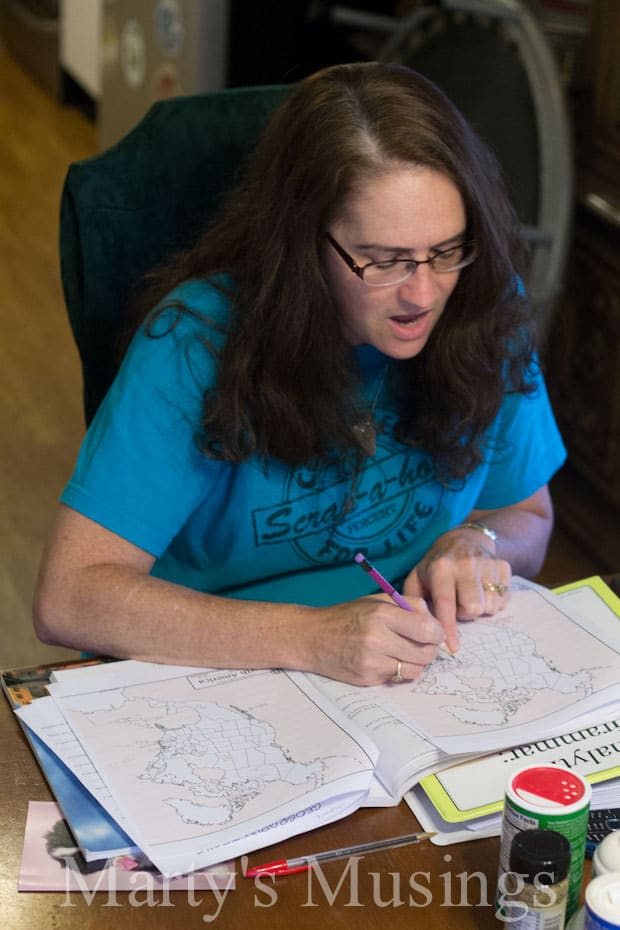 A woman sitting at a table looking at a book