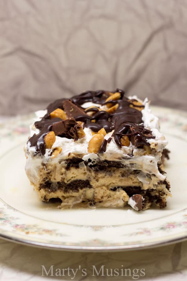 A piece of chocolate cake on a plate, with Peanut butter cup and Cream