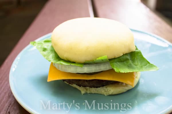 A sandwich sitting on top of a paper plate, with Bun and Hamburger
