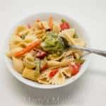 A bowl of food on a plate, with Pasta and Salad