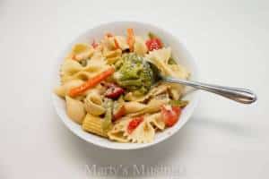 A bowl of food on a plate, with Pasta and Salad