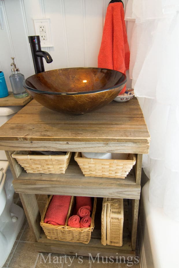 A stove top oven sitting inside of a bowl, with Bathroom and Fence
