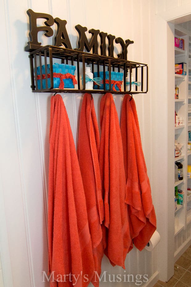 Beadboard paneling and coral towels in bathroom