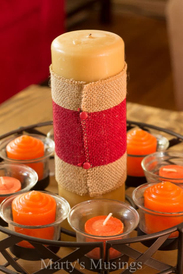 A bowl of oranges on a table, with All Things Home and Candle