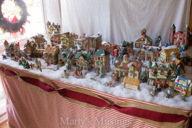 Christmas village set up in front of hanging sheet during daylight