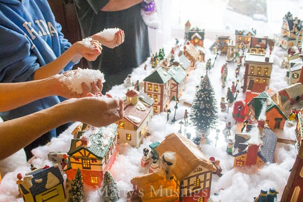 Throwing snow on top of Christmas village