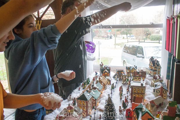 Throwing snow on top of Christmas village