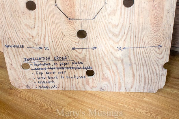 Directions on plywood for setting up Christmas village