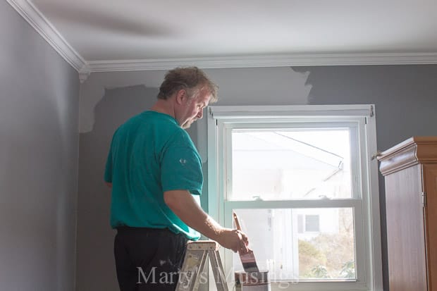 A man standing in front of a window, with BEHR Premium Plus