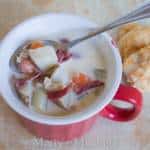 A bowl of food on a plate, with Chowder and Clam