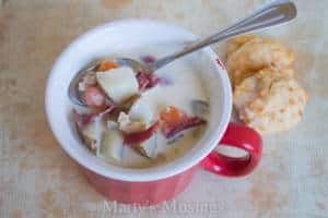 A bowl of food on a plate, with Chowder and Clam