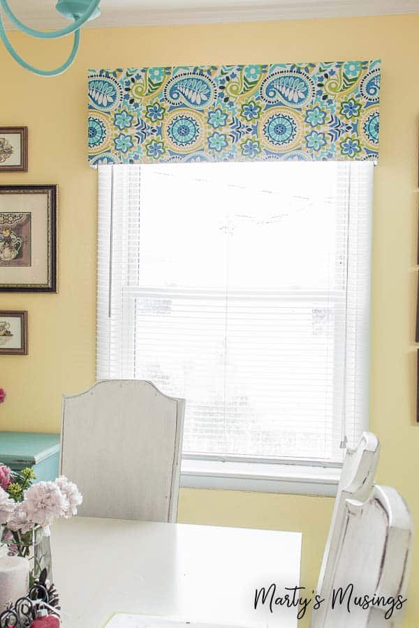 Room with yellow walls and floral window valance