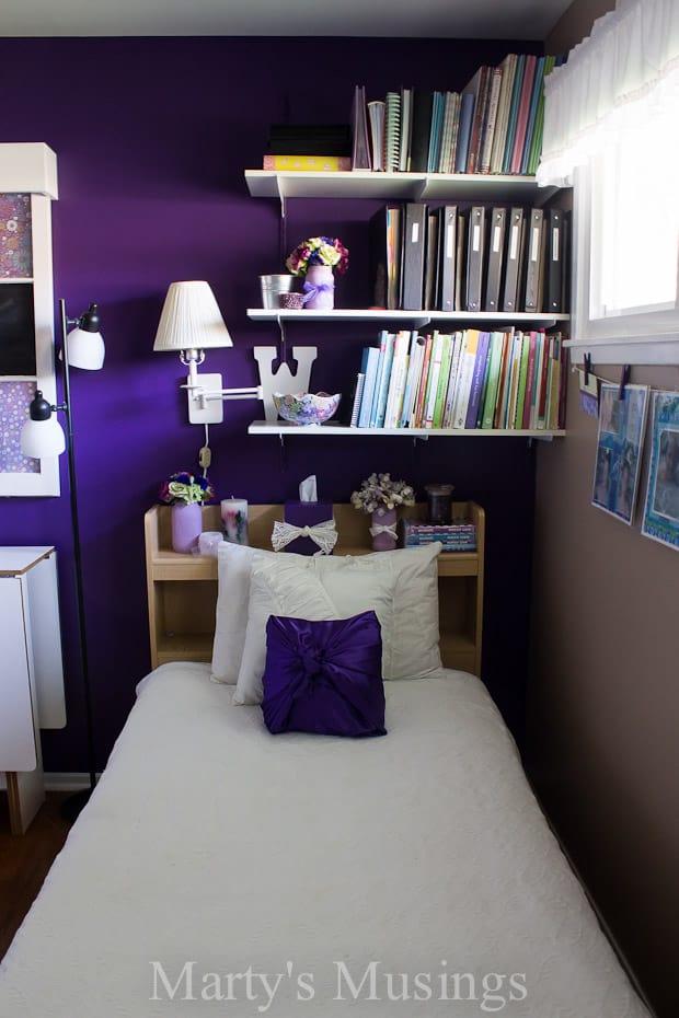 A bedroom with a bed and desk in a small room