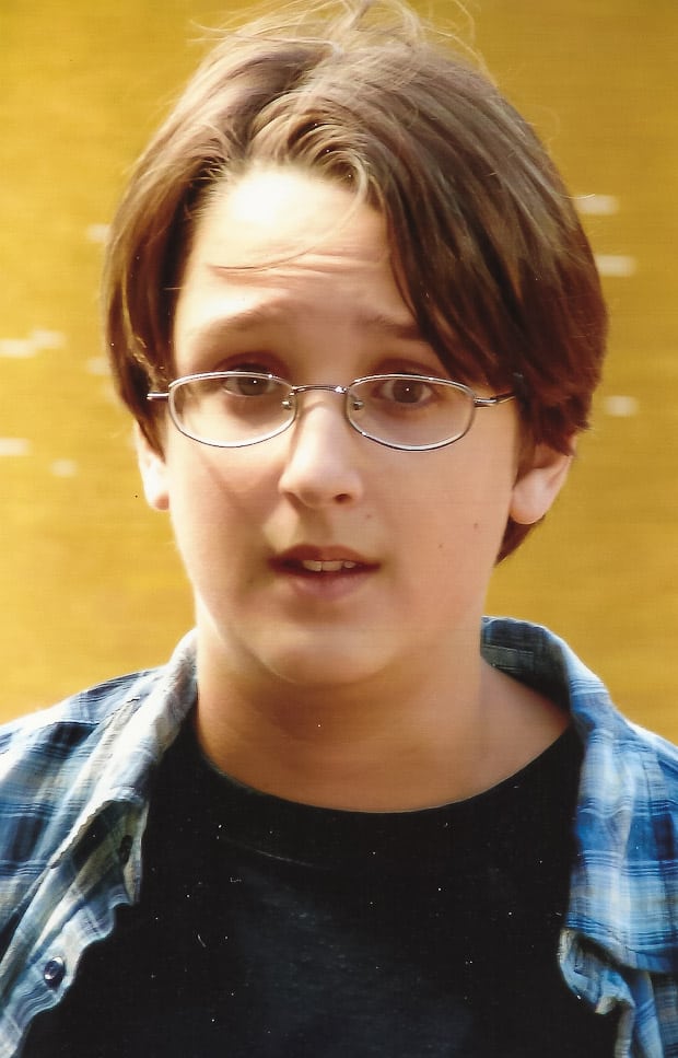 A woman wearing glasses and smiling at the camera