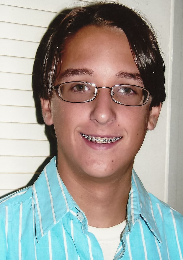 A woman wearing glasses and smiling at the camera