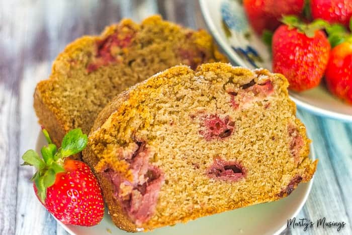 A close up of a plate of food with a slice of cake, with Bread and Strawberry