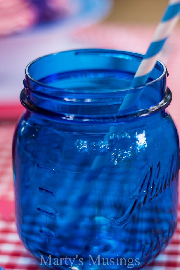 A glass with a blue bottle, with Napkin and Jar