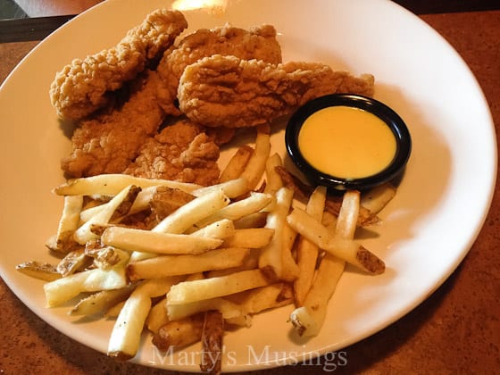 A plate of food that is on the side of fries, with Chicken and French fries