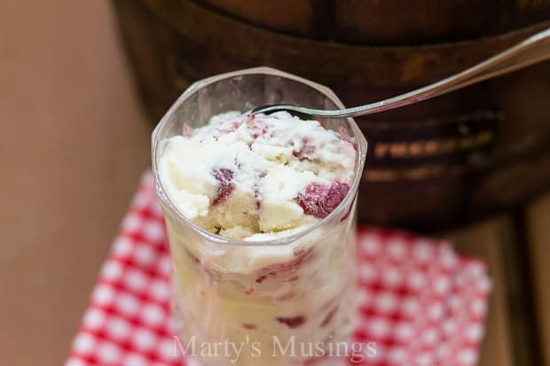 A glass cup on a table, with Ice cream