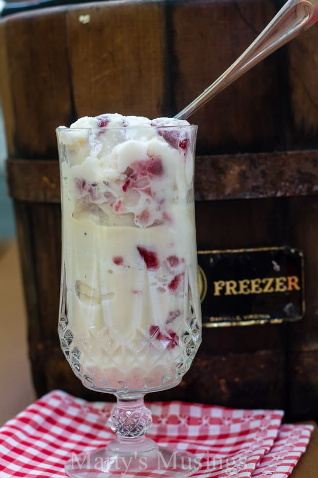 A glass cup on a table, with Ice cream