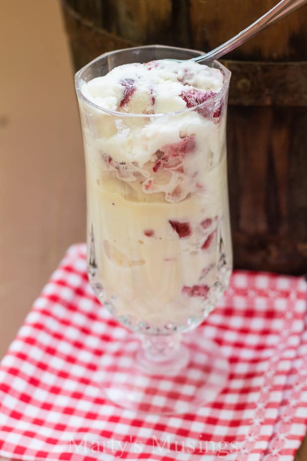 A glass cup on a table, with Ice cream