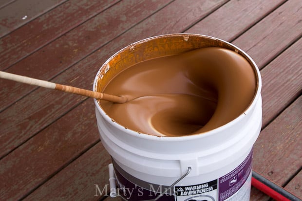 A cup of coffee sitting on top of a wooden table, with Deck and Behr