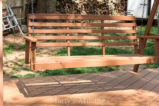 An empty park bench sitting on top of a wooden fence