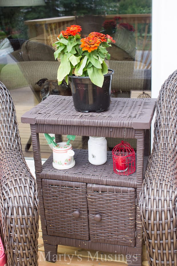 A basket filled with furniture and vase of flowers on a table