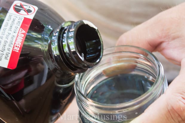 pouring Citronella into mason jar for Candles 