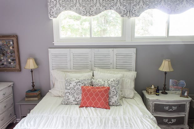 A bedroom with a bed and desk in a room