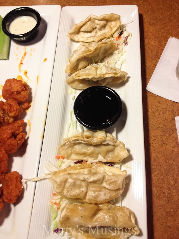 A box filled with different types of food on a table, with TGI Fridays and Dipping sauce