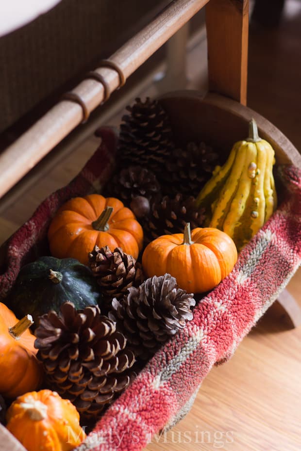 A bowl of fruit sitting on top of a wooden table, with Gourd