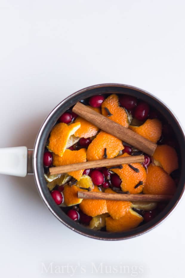 Homemade potpourri in sauce pan with oranges, cinnamon sticks and cranberries 